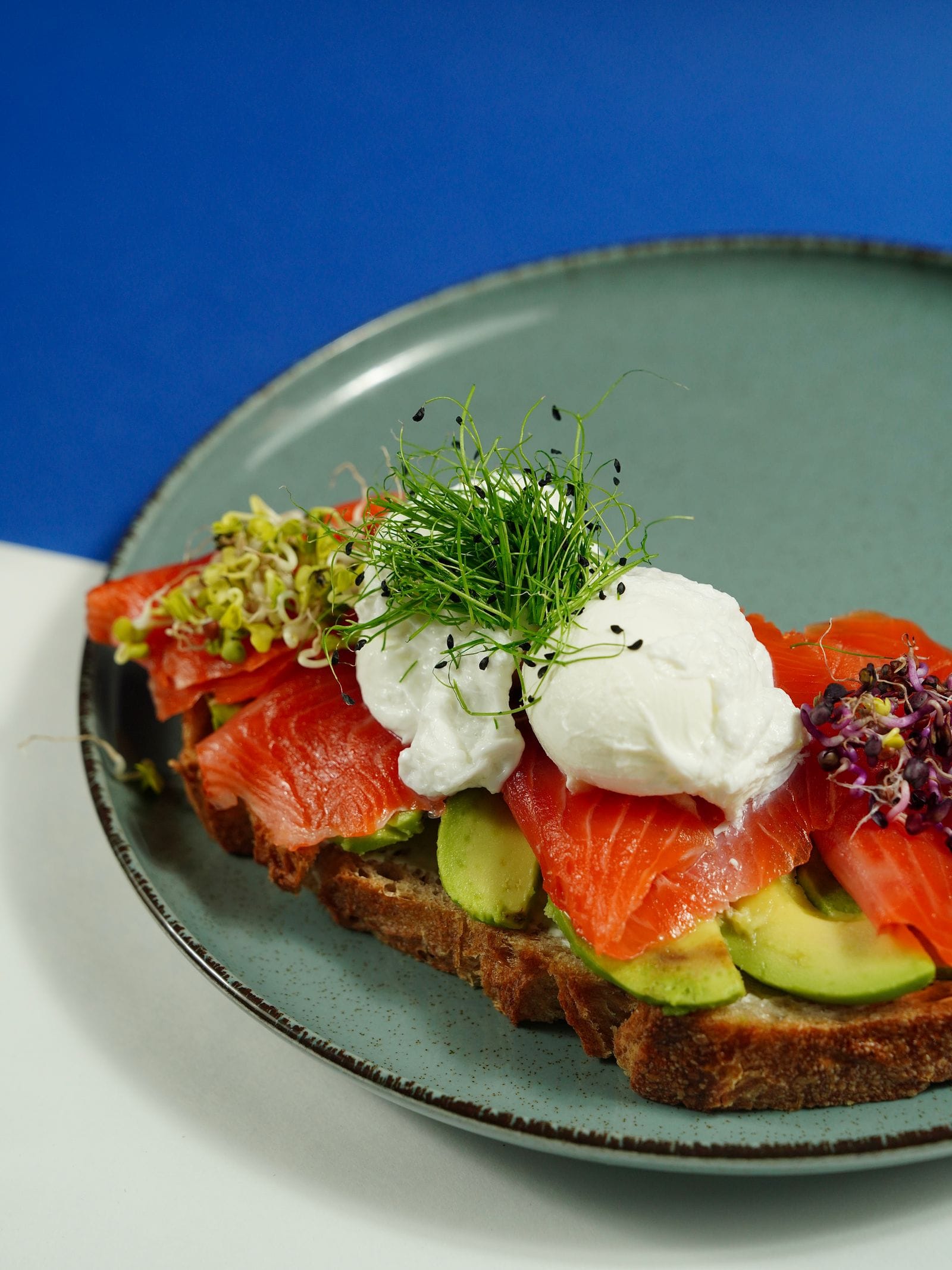 Toast met gerookte zalm en avocado op een bord, een snelle lunch met vette vis en magnesium